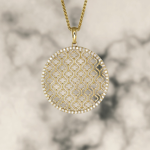 Large circular gold and diamond basketweave pendant on chain in front of marble background