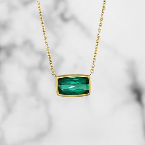 green tourmaline cushion cut pendant which is bezel set on a cable chain